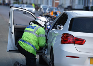 A member of the Road Harm Prevention Teams stops and talks to a driver during Operation Safer Junction