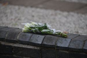 One bunch of flowers has been left on a wall