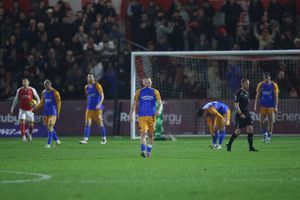 Dejected Shrewsbury Town players react after conceding a third goal