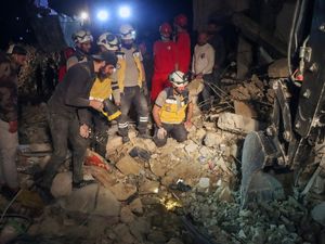 Rescuers the White Helmets search through debris