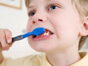 A small boy brushing teeth