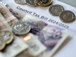 Banknotes and coins on top of a council tax bill