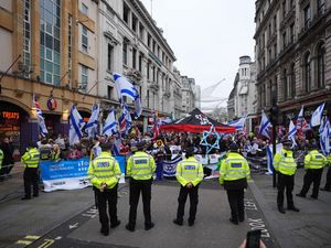 Police watch a counter-protest near Piccadilly Circus during a Palestine Solidarity Campaign rally in central London