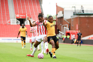STOKE ON TRENT, ENGLAND - JULY 26: Bosun Lawal of Stoke City is challenged by Jean-Ricner Bellegarde of Wolverhampton Wanderers during the pre-season friendly match between Stoke City and Wolverhampton Wanderers at Bet365 Stadium on July 26, 2025 in Stoke on Trent, England. (Photo by Wolverhampton Wanderers FC/Wolves via Getty Images)