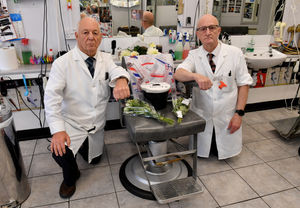 Antony Pearson and Mervyn Pearson senior pose next to some of the tributes left to Mervyn Pearson