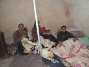 Some of Sefik's family in a tent next to their temporary home