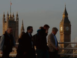 Commuters in London with the Palace of Westminster in the background