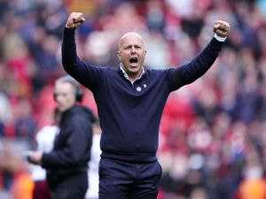 Liverpool head Arne Slot celebrates with both arms in the air