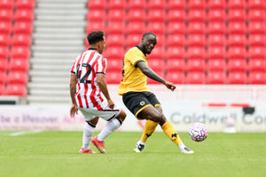 STOKE ON TRENT, ENGLAND - JULY 26: Toti Gomes of Wolverhampton Wanderers passes the ball whilst under pressure from Million Manhoef of Stoke City during the pre-season friendly match between Stoke City and Wolverhampton Wanderers at Bet365 Stadium on July 26, 2025 in Stoke on Trent, England. (Photo by Wolverhampton Wanderers FC/Wolves via Getty Images)