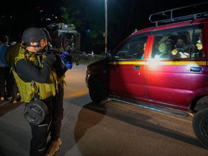 Indian police point guns at people in a large car near Pahalgam