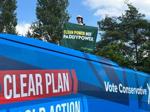 Supporting image for story: Greenpeace protester mounts Tory bus demanding ‘clean power not Paddy Power’