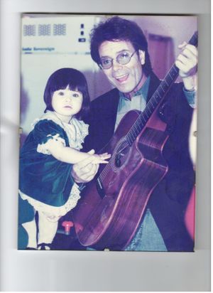 Cliff Richard with 'living doll' Sophie Poduval, Dave Pope's 14-month-old god-daughter, at a street party in Lower Gornal in December, 1993
