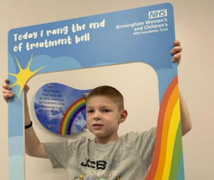 Dylan with the end of treatment bell