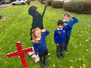 Children from Landywood Primary School [L-R] Lola Barton, 6, Dev Chamdal, 7 and Rowan Perry, 9, mark Remembrance Day at Waters Edge Care Home.