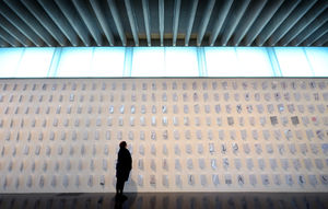 Part of the exhibition features over 1000 pieces of laminated paper stuck to the walls with different rubber stamp artwork on them