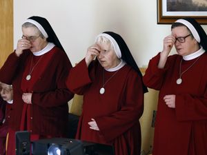 Sisters of the Redemptoristine Nuns, crossing themselves