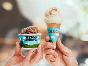 Hands holding up Ben & Jerry's ice cream tub and cone