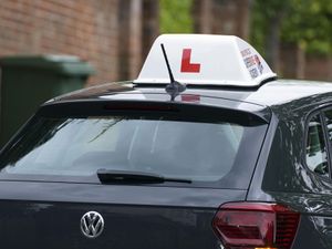 A driving instructor's car with an L sign on top