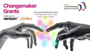 Two hands touching to create a colourful spark. Unloc Changemaker Grants, powered by The Changemaker Alliance and Verizon Business