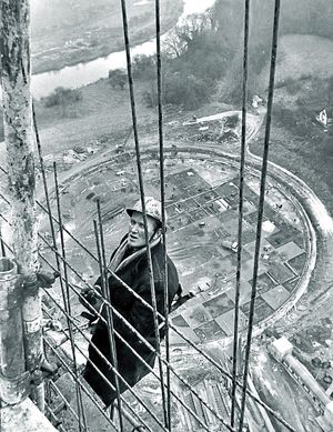 Work on one of the cooling towers. It was taken on November 22, 1966. The original caption read: 'Tower foreman Mr John Costello fixes outside shuttering near the top of cooling tower 3. Down below the foundations of tower 4 and the curve of the River Severn are clearly visible.' 
