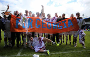 AFC Telford United players celebrate winning the Skrill Conference North championship with a banner reading 'For Georgia' in memory of teenager Georgia Williams