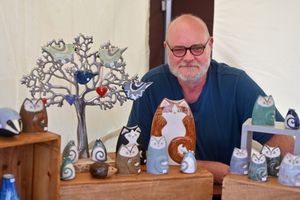 Adam Billingsley with the unique animal artwork of Helen Billingsley at the folk festival