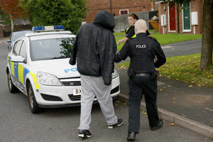 Officers lead away a suspect in Operation No Deal