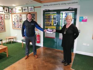 Pave Aways’ construction director Jamie Evans delivering 10 tablets to Caroline Jones at Welshpool High School