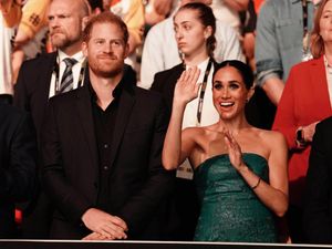 Meghan waves she watches the Invictus Games in Dusseldorf with Harry