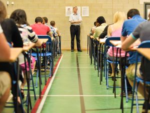 Pupils sitting exams in a hall.