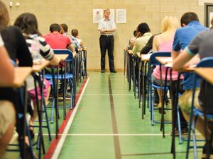 Pupils sitting exams in a hall.