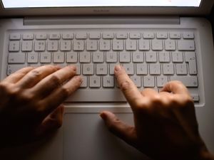 Generic stock photo showing a woman’s hands using a laptop keyboard