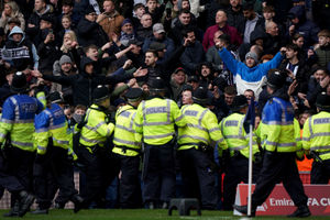 Police officers on the pitch after the match was halted