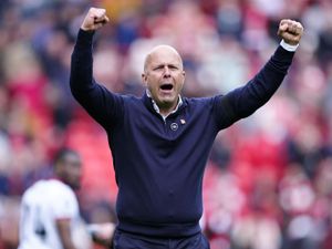 Liverpool head coach Arne Slot raises both arms in celebration