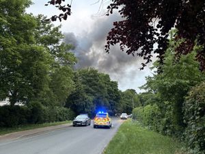 Police cars block the road near the scene of a blaze at former RAF Bicester