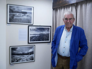 Renowned photographer Richard Surman with three of his exhibits at the Old Picture House in Kington. Image by Andy Compton