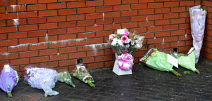 The first flowers left in tribute outside the house