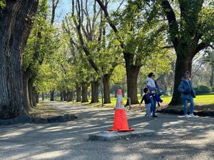 People walk near a traffic cone where a monument of British explorer Capt. James Cook once stood before it was removed following continued vandalism at a park Melbourne, Australia