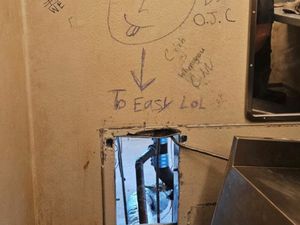 A hole in the wall where the prisoners escaped with "To Easy Lol" written above it