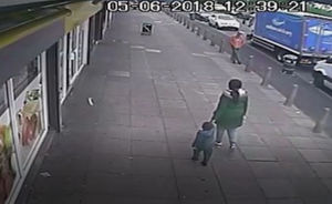 A CCTV image of Kemarni walking with his mother Alicia Watson in West Bromwich on the day of his death