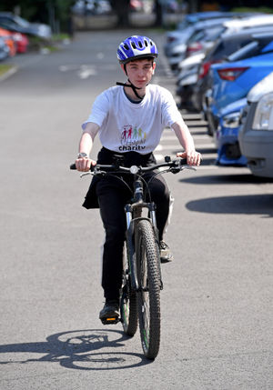 Chris Doyle finishing his charity 100 mile cycle ride at Burton Borough School, Newport