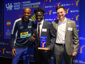 Sir Mo Farah and Sports Direct's marketing manager Jamie Stewart present Ouskh Dampha with his award at the Youth Sport Trust Young Changemaker Awards 2024