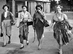 August 8, 1955. The caption reads: 'Travel weary, and a little cold despite the sunny weather, 54 Malayan students arrived at Brinsford Lodge, near Wolverhampton, shortly before seven o'clock last night, having landed at London airport earlier in the day from their homeland. The students, whose ages range from 18 to 22, will be spending the next two years at Brinsford Lodge, the former industrial hostel, where they will be trained as teachers. Pictured above are three of the students, left to right, Tan Kheng Poh, Khapijah Awang and Khaw Siok Choon and Miss M. Morris (geography lecturer). About 100 more Malayan students are due to arrive later in the year.. Brinsford Lodge is the second college of its kind to be opened by the Malayan Government in this country.'