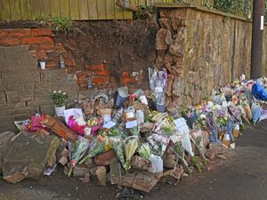 A growing pile of tributes has been left at the roadside