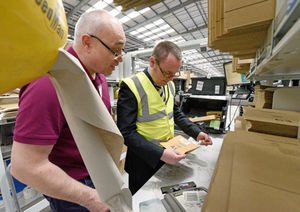 Dave Waziuk shows Mark Andrews how to process a delivery at the Amazon warehouse in Rugeley