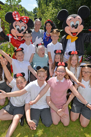 Resident Margaret Robinson with staff and children from Lower Farm school