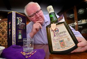 Pic at Old Mill Antiques in Bridgnorth of owner: John Ridgway which a very unusual bottle of Whisky for sale. Sell or drink...John ponders the decision.