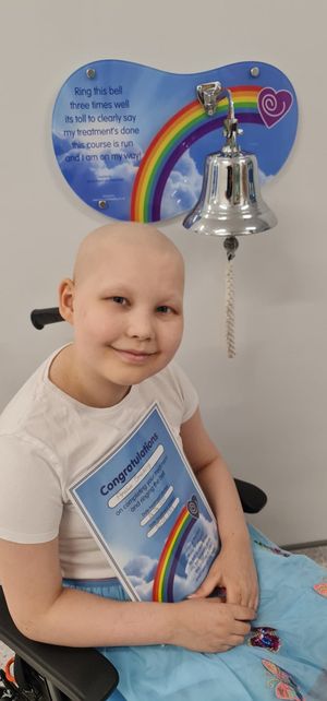 Amelia ringing the end of treatment bell at hospital