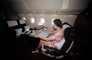 Queen Elizabeth II looking through an album of photographs during her flight home from Bridgetown, Barbados, in Concorde after her Silver Jubilee tour of the Caribbean in 1977
