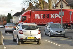 Cars parked on the corner of a mini roundabout have added to congestion